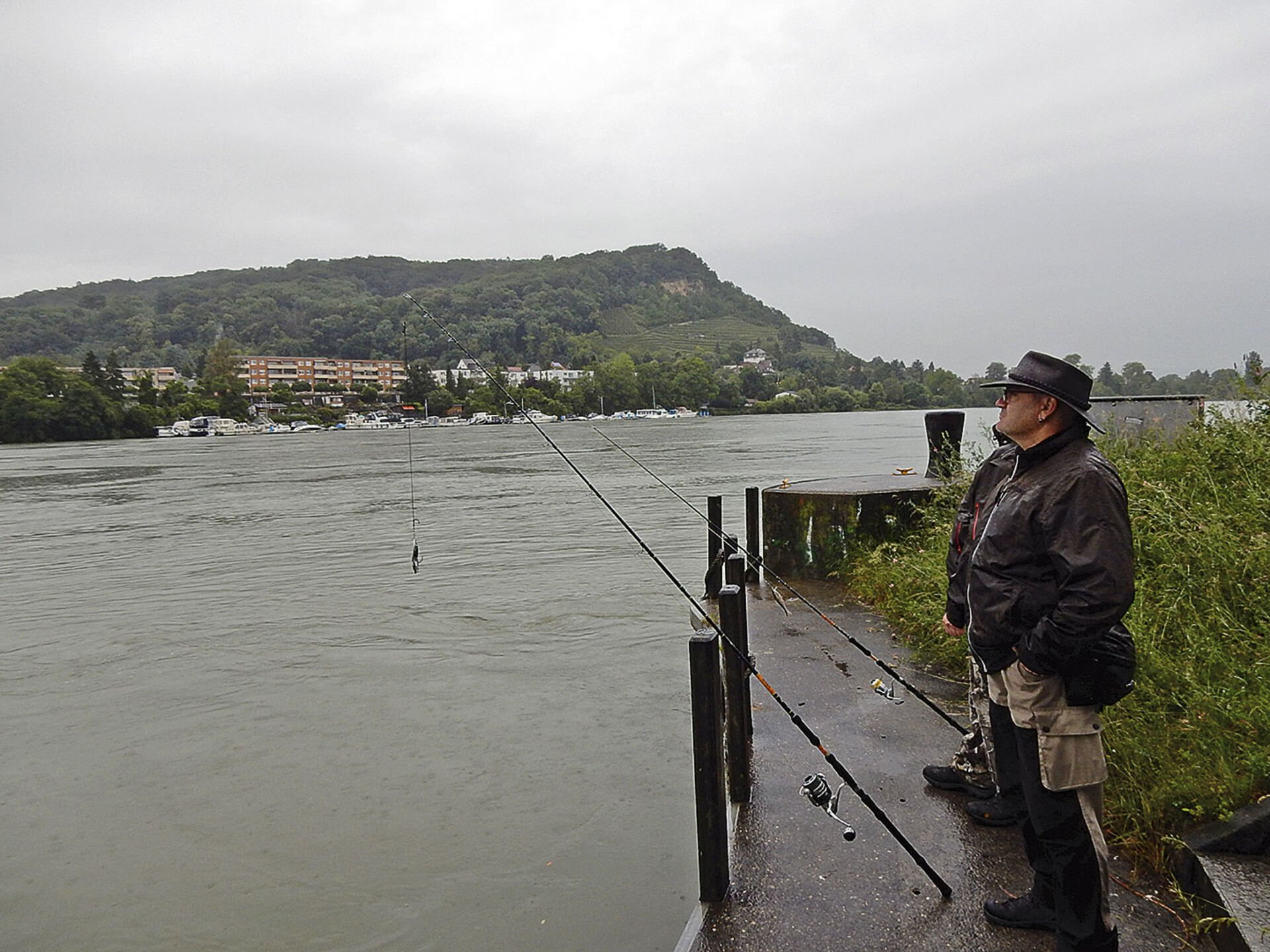  Spinnfischen auf Wels im strömenden Regen kann anstrengend sein: Daniel Madörin und sein Fischerkumpel Alain Bernet (verdeckt) legen auf der Kraftwerkinsel Birsfelden eine Pause ein.  