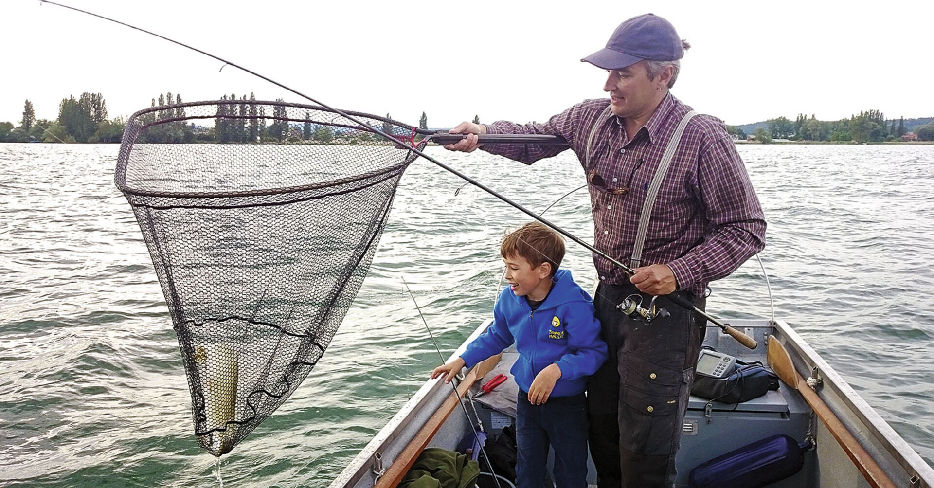  Der erste Hecht ist im Boot. Vater und Sohn sind glücklich.  
