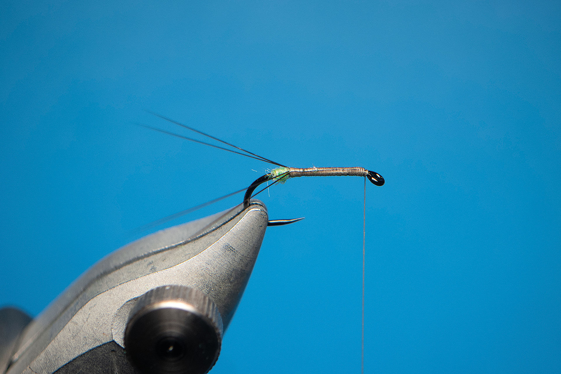  3. Binde der Länge nach auf jeder Hakenseite je zwei Mayfly Tails ein, die doppelt so lang wie der Körper sind. Dank der Dubbingkugel stehen diese schön zur Seite ab.   