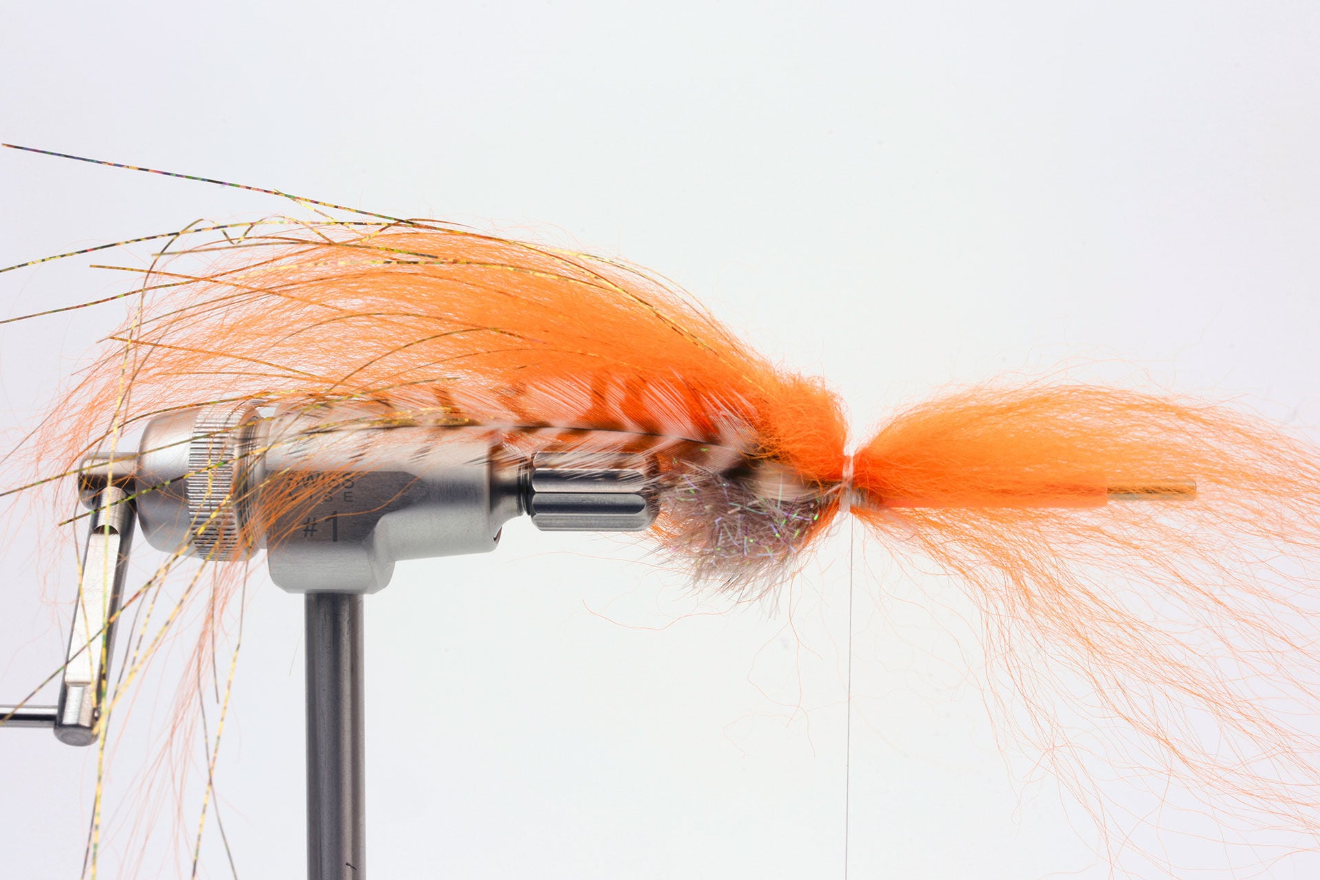  5. Nun binde eine Hechel ein und anschliessend einen Büschel Streamer Hair verkehrt herum. Dieses «Reverse Tying» sorgt für zusätzliches Volumen!  